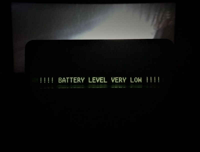 A captioning device in a movie theater with the words: "!!!! Battery Level Very Low !!!!"
