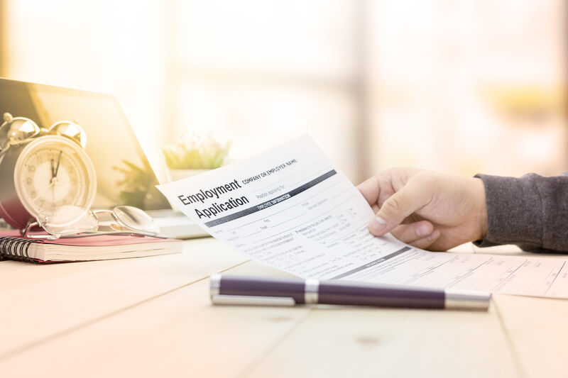 A job application form in the hand of a job applicant