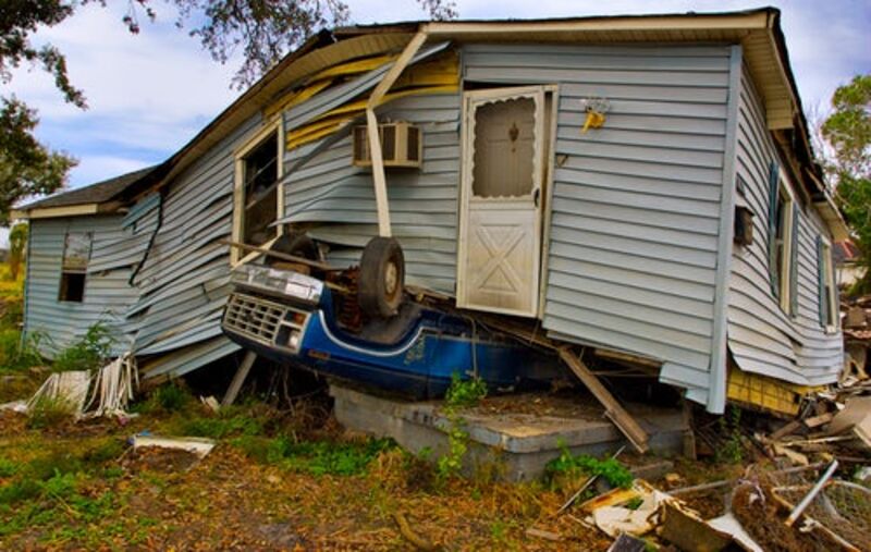 A blue house on top of a blue truck after a tornado.