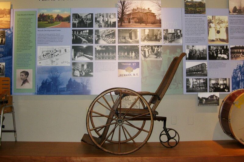 Old wooden wheelchair on display.