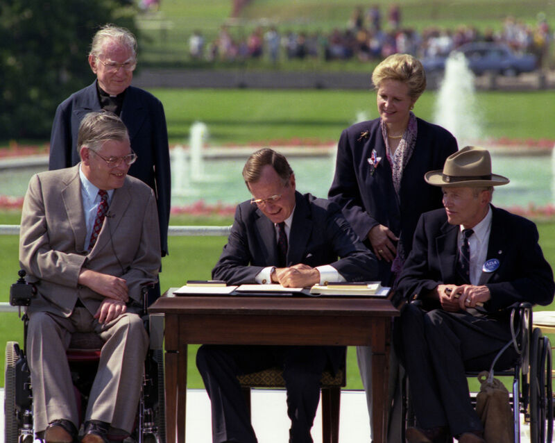 George HW Bush signing the Americans with Disabilities Act into law.