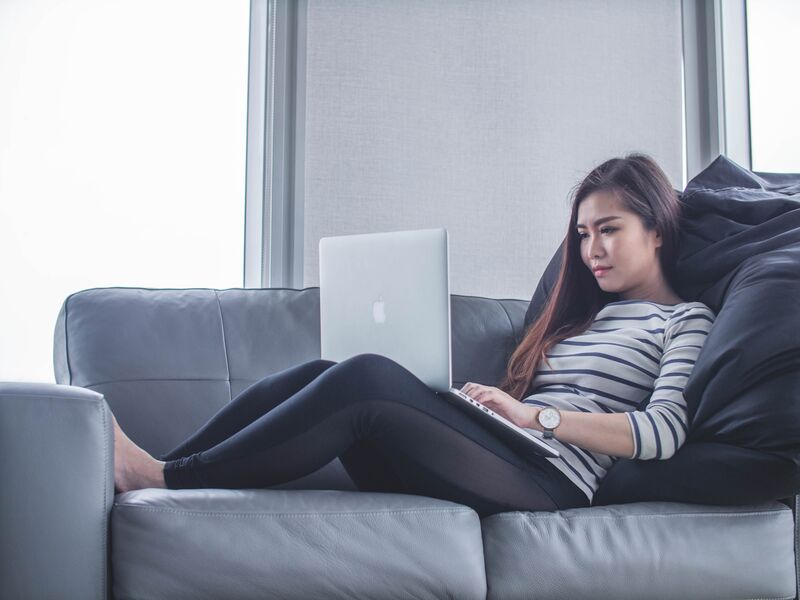 Woman on a couch working on a laptop