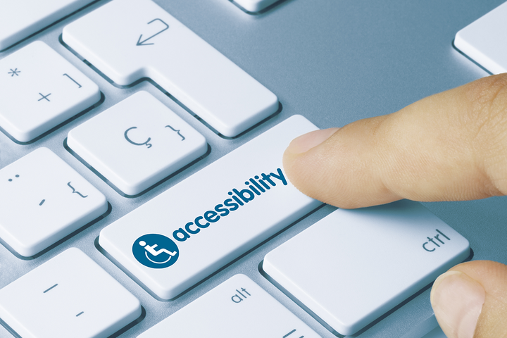 a close up of someone pressing a button on a keyboard with an accessibility wheelchair icon